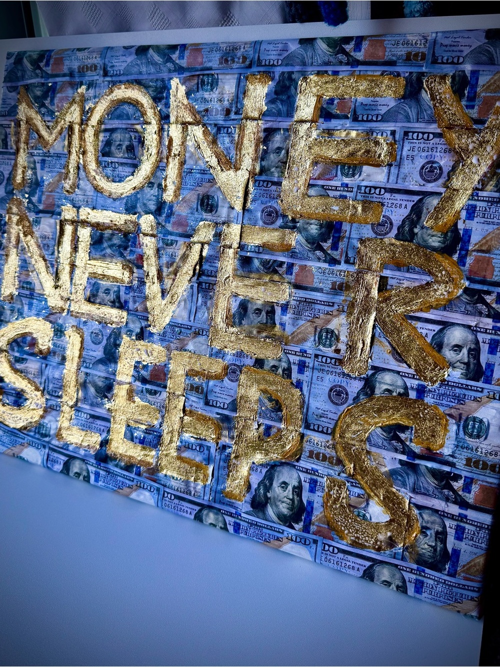 Gold Text "Money Never Sleeps" Wall Art on Blue Money Collage